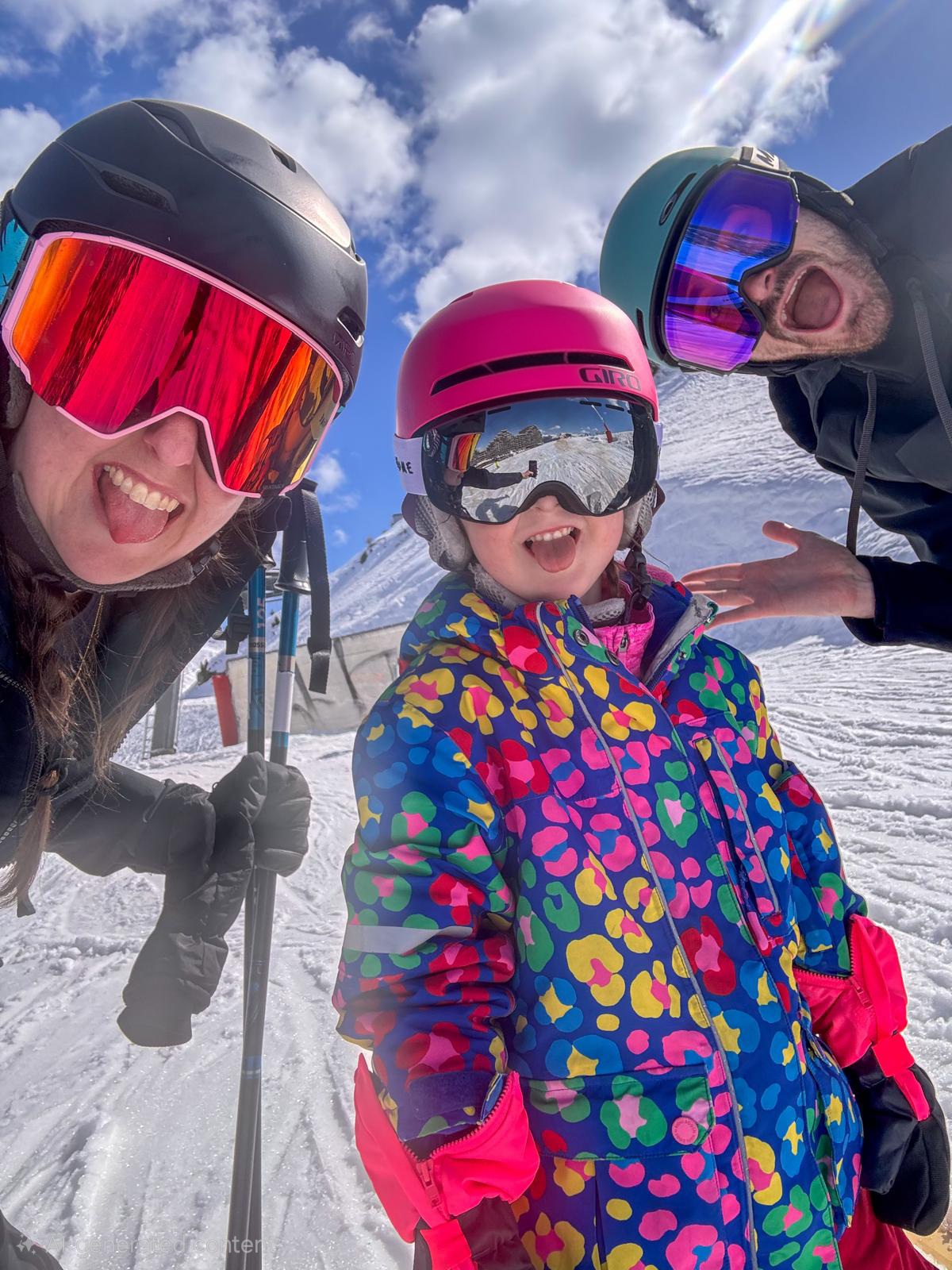 The founding family on the slopes — two adults and a child in ski gear, all smiling.